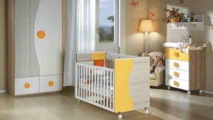 DORMITORIO INFANTIL CON ARMARIO DE DOS PUERTAS, CUNA, CÓMODA DE CAJONES Y ESTANTE DE PARED CON PERCHERO.