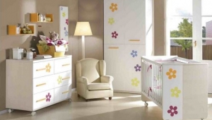 DORMITORIO INFANTIL CON CUNA , CÓMODA DE CINCO CAJONES Y ESTANTES DE PARED.