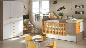 DORMITORIO INFANTIL CON CUNA CONVERTIBLE EN ACABADO NOGAL, COMBINADO CON NARANJA Y BLANCO.