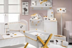 DORMITORIO INFANTIL CON CUNA , CUCO Y CÓMODA CAMBIADOR DE CAJONES Y PUERTA. DIFERENTES TEXTILES PARA VESTIR LOS MUEBLES DE PUERICULTURA.