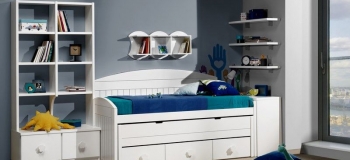 DORMITORIO INFANTIL LACADO EN BLANCO. COMPUESTO POR : CAMA COMPACTA CON BAJO DE CAJONES, ARCÓN CON TAPA ELEVABLE, ESTANTERÍAS, MÓDULOS Y ESTANTES DE PARED Y GAVETAS.