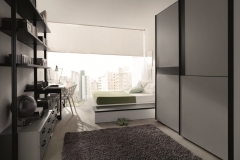 DORMITORIO JUVENIL CON TATAMI CON ARCONES ABATIBLES, ESTANTERÍAS METÁLICAS, ARMARIO Y MESA ESTUDIO.